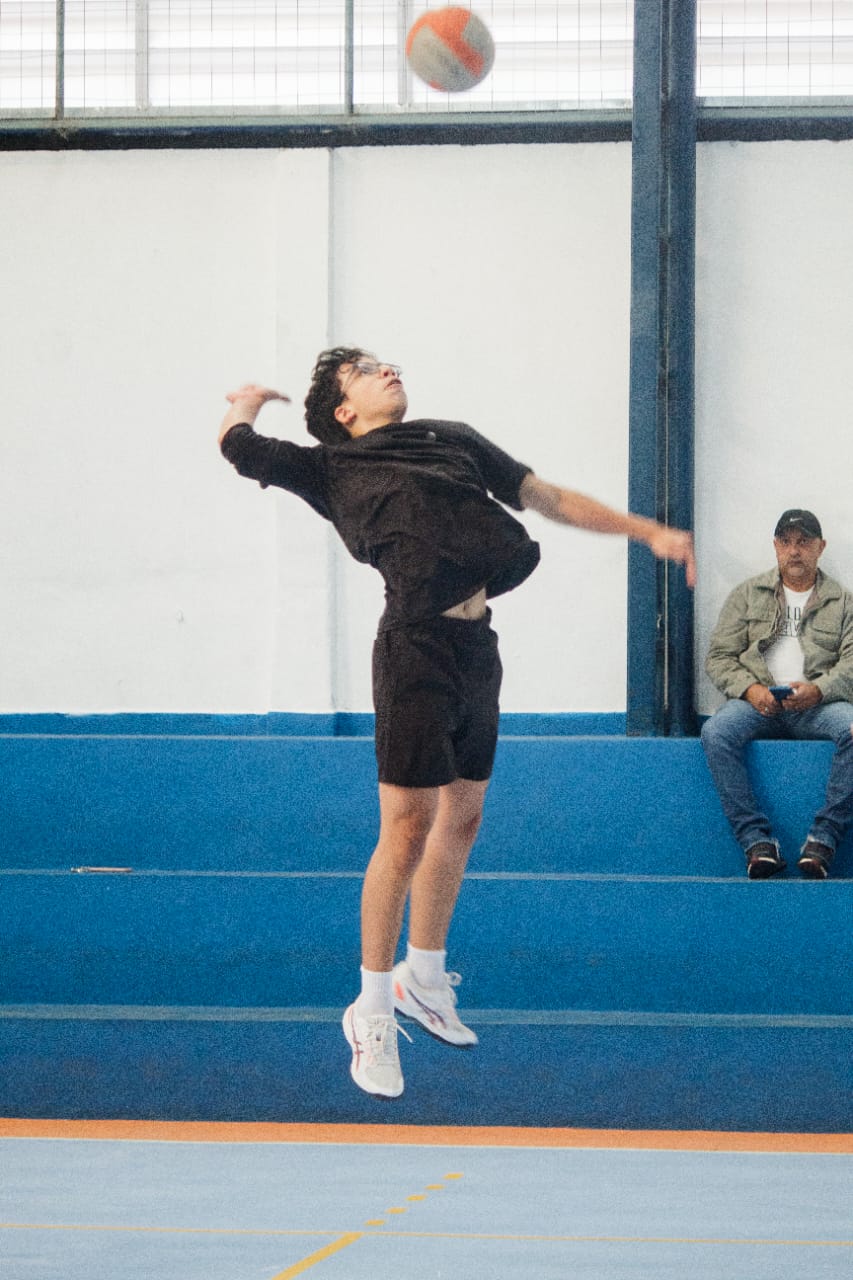 Aluno da Astro Jovem saltando para atacar no vôlei